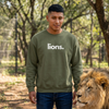 Model wearing an olive green Lions crewneck sweatshirt next to a real lion — wildlife-lover sweatshirt supporting no-kill animal rescues